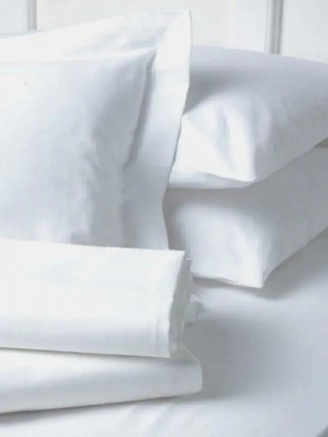 Pile de draps plats professionnels blancs pliés pour l'hôtellerie