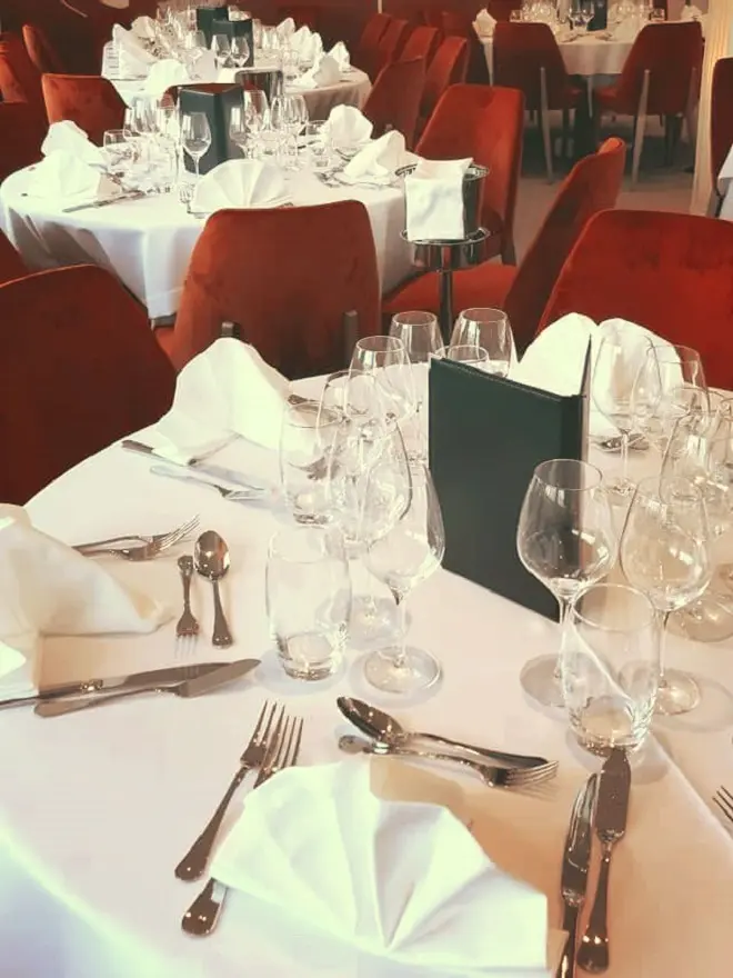 Dressage de table professionnel avec nappage blanc et serviettes pliées pour restaurant