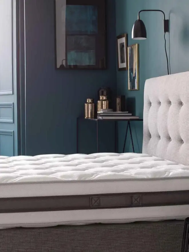 Matelas d'hôtellerie haut de gamme épaisseur confort, installé sur un sommier tapissier dans une chambre d'hôtel.