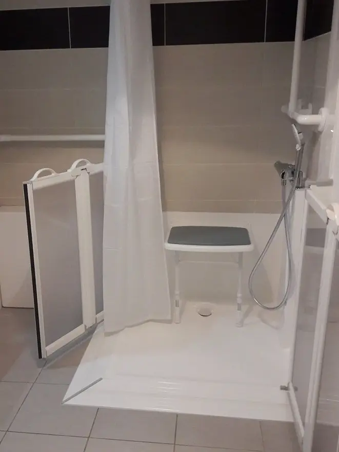 Salle de bain médicalisée équipée d'un rideau de douche norme Non Feu M1